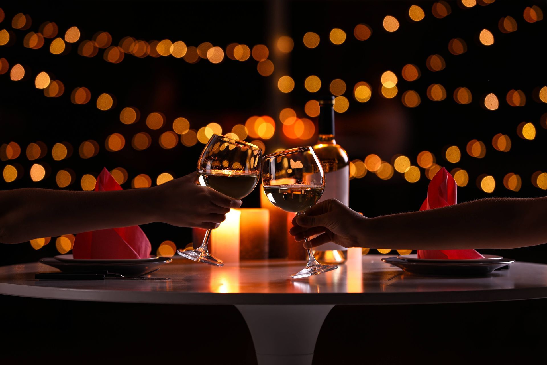 Young couple with glasses of wine having romantic candlelight dinner at a table at Kentucky River Tours near Frankfort, KY