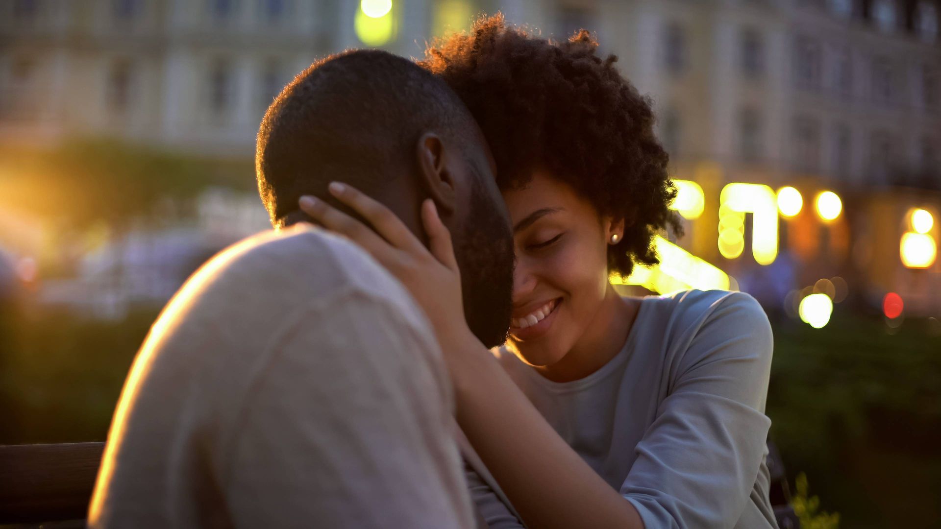 Pretty woman tenderly stroking boyfriend's face while on a sunset date at Kentucky River Tours near 