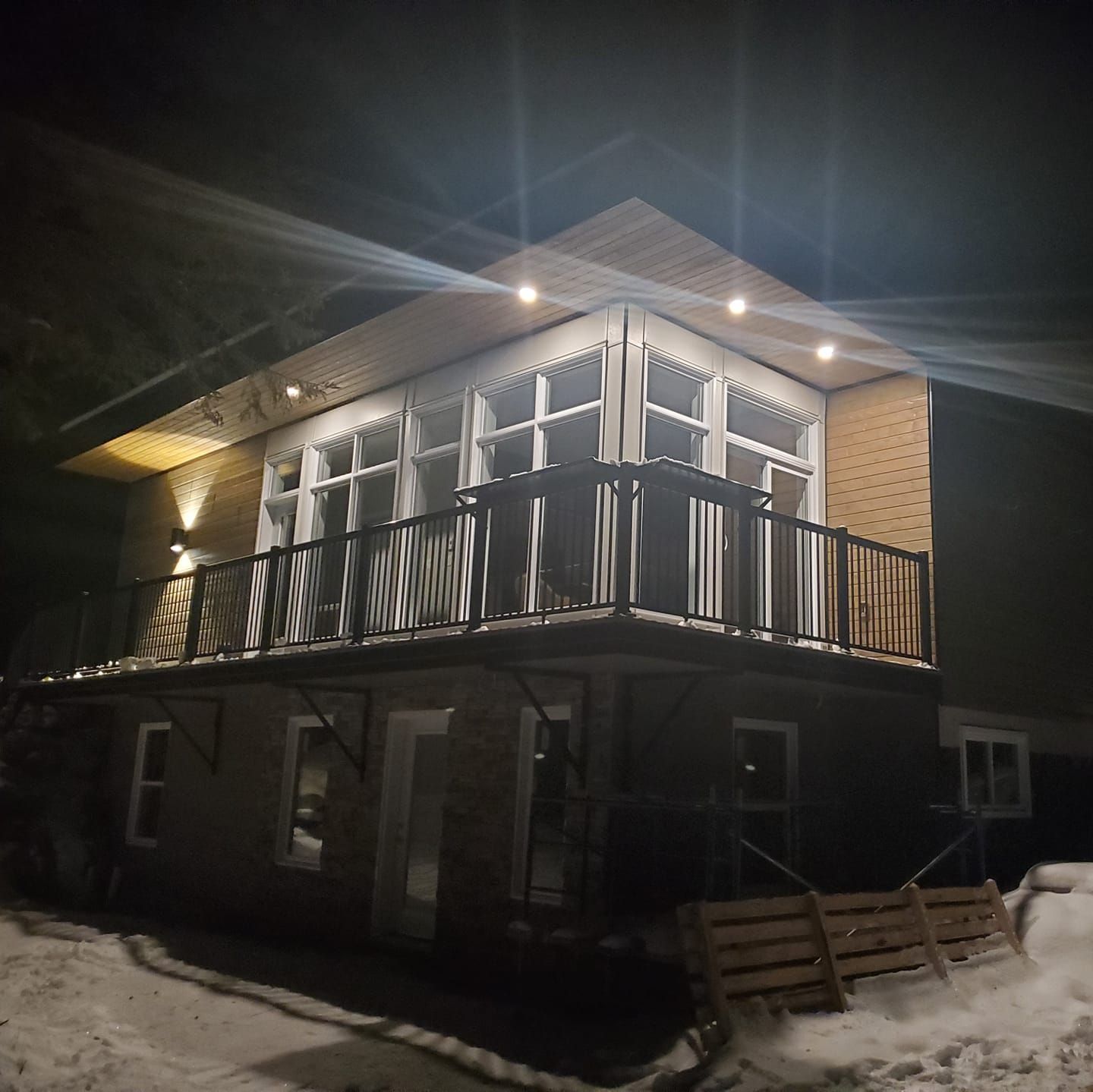 Une maison avec un balcon est éclairée la nuit