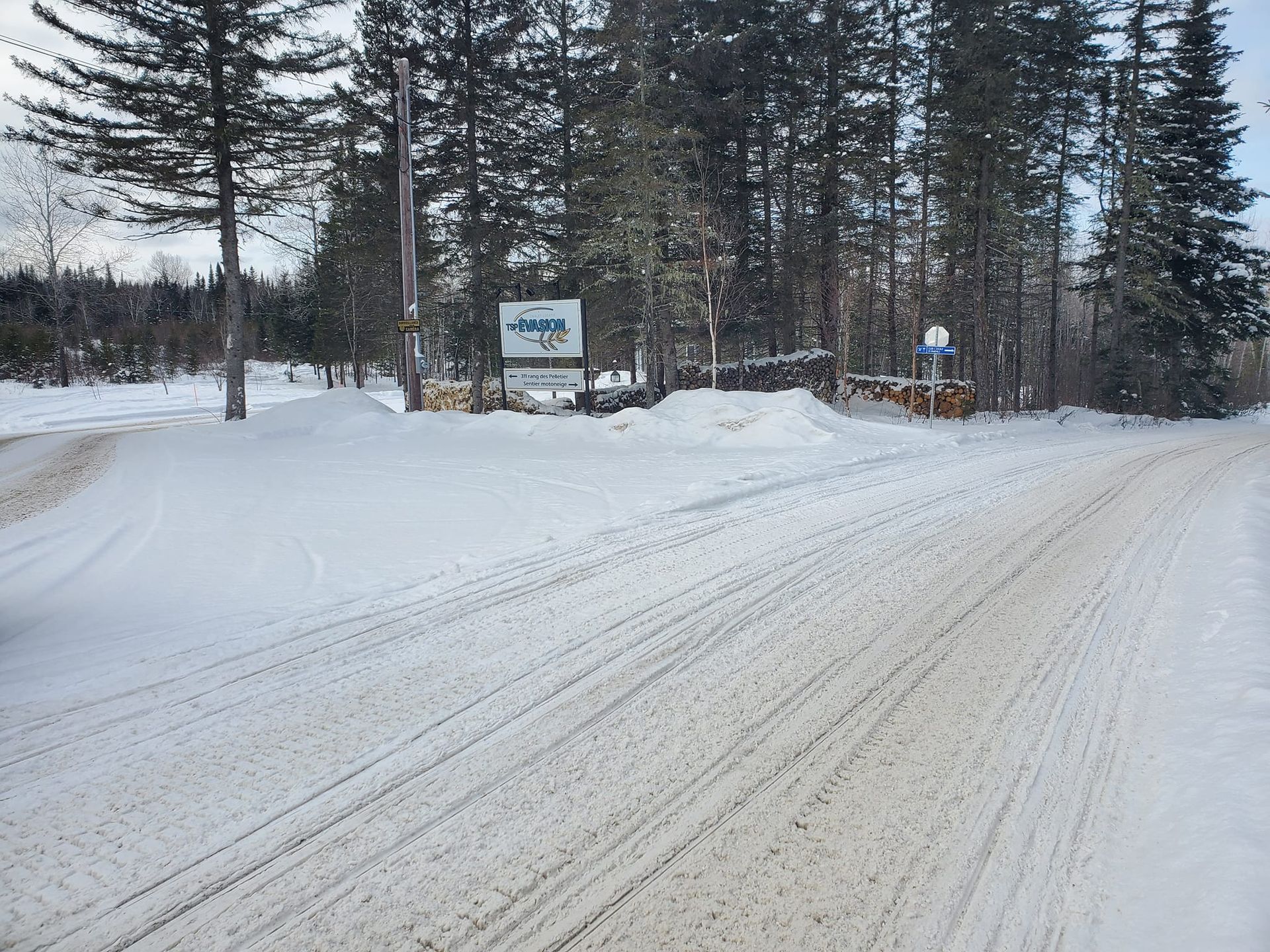 Une route enneigée avec un panneau au milieu