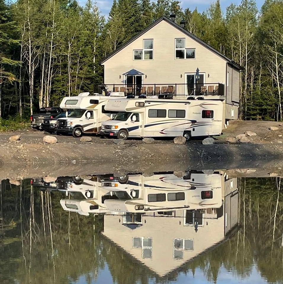 Une rangée de camping-cars est garée devant une maison