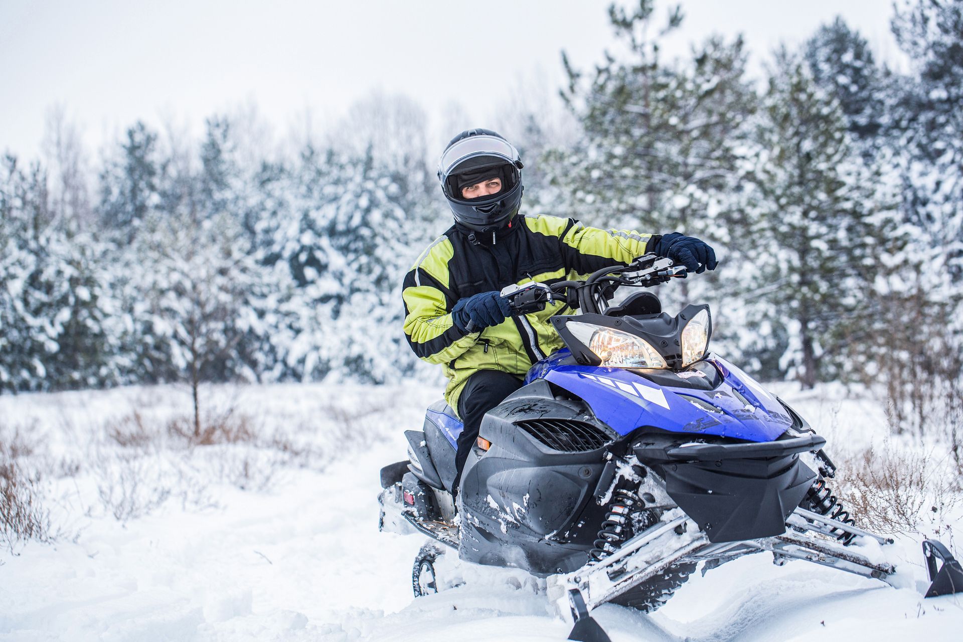 Un homme conduit une motoneige dans la neige.