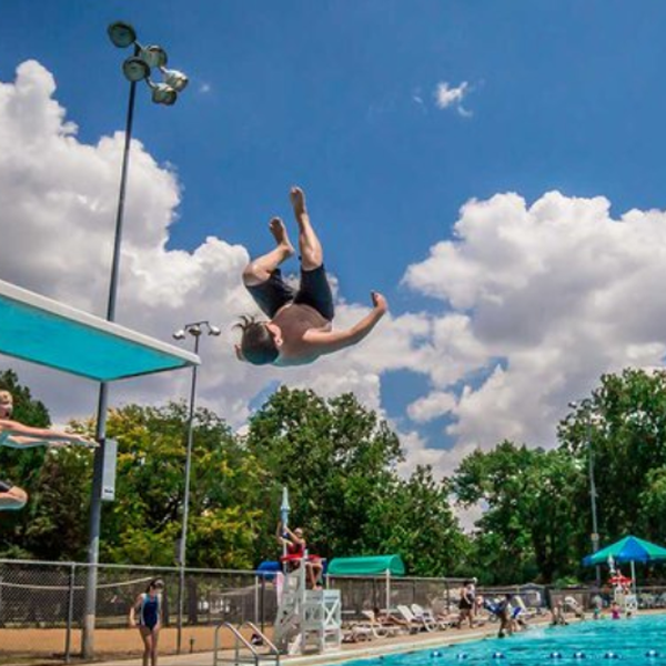 kid jumping of diving board into a pool