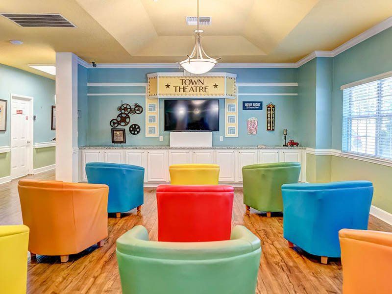 A room filled with colorful chairs and a flat screen tv.