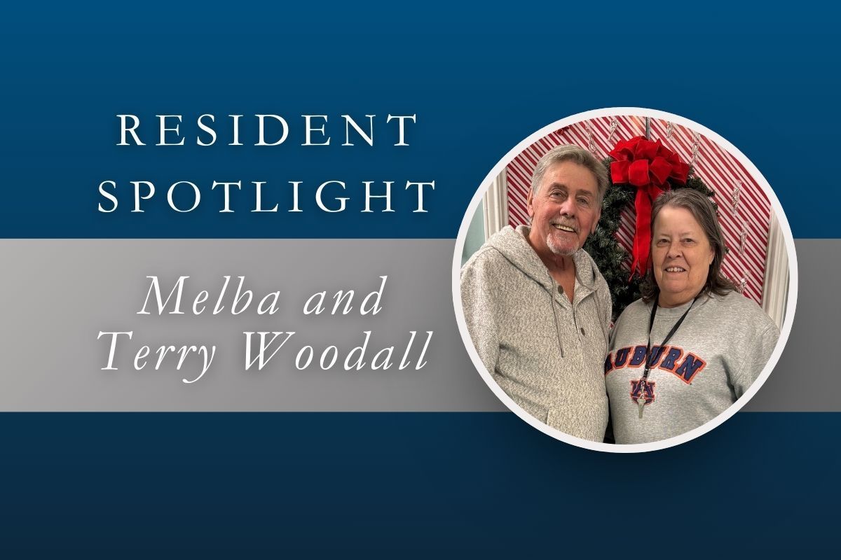 Resident Spotlight: Melba and Terry Woodall. Smiling couple posing indoors in front of festive decoration.