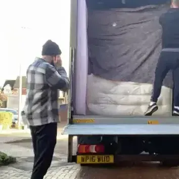 A man in a plaid shirt is standing next to a truck.