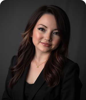 The woman is wearing a black jacket and a gold necklace.