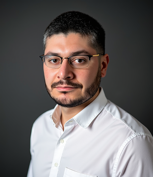 A man with a beard and glasses is wearing a white shirt.
