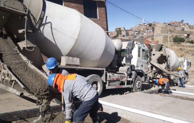 Un camión hormigonera está vertiendo hormigón en el suelo.