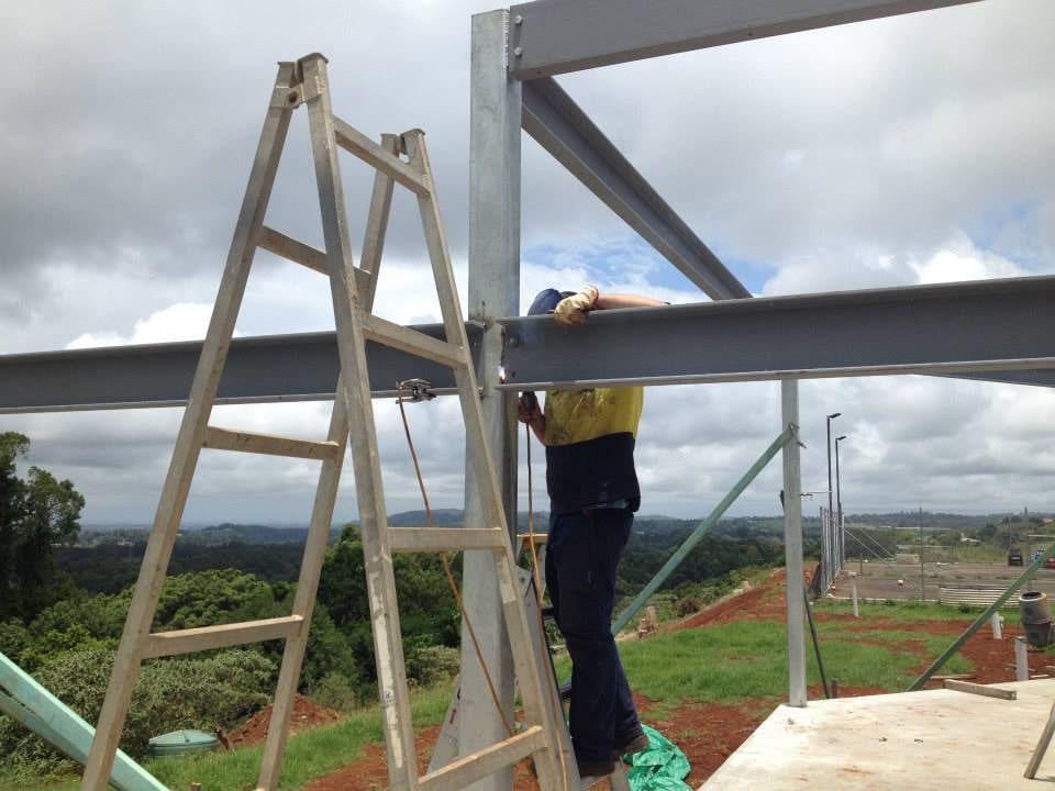 A Man on a Ladder Working on a Metal Structure — North Coast Steel Fabrication in South Lismore, NSW