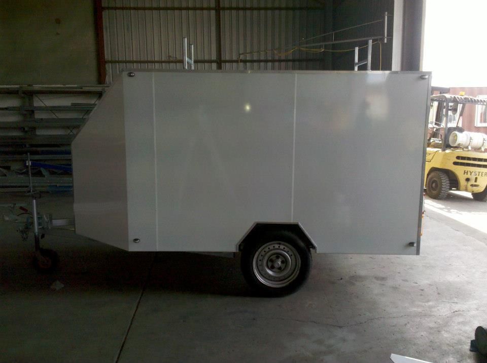 A White Trailer is Parked in a Garage Next to a Yellow Forklift — North Coast Steel Fabrication in South Lismore, NSW