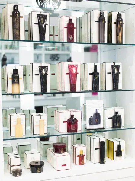 Shelves displaying cosmetic products in white boxes with black accents.