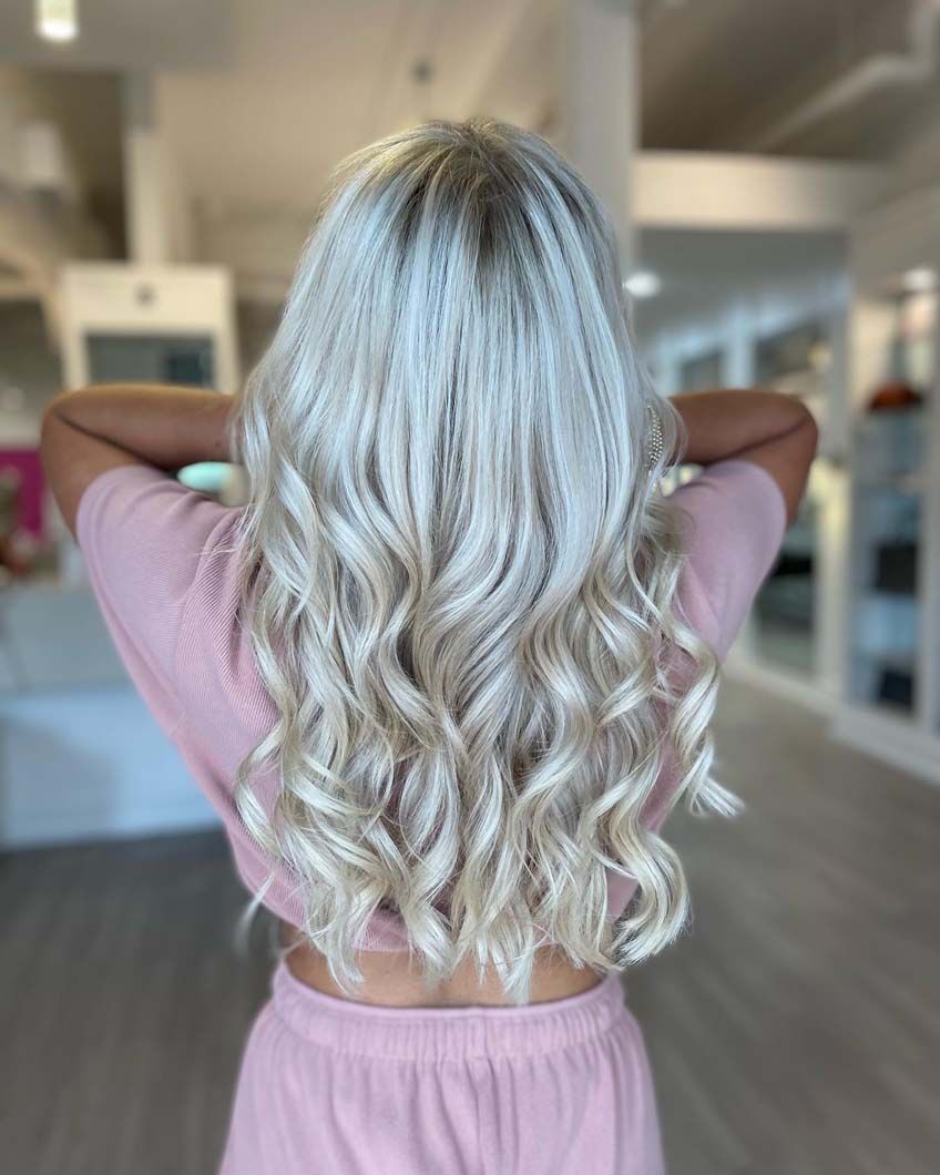 Blonde wavy hair, back view, over pink outfit.