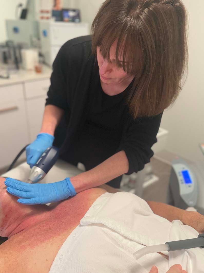 Person in blue gloves using a device on a person's red chest in a medical setting.
