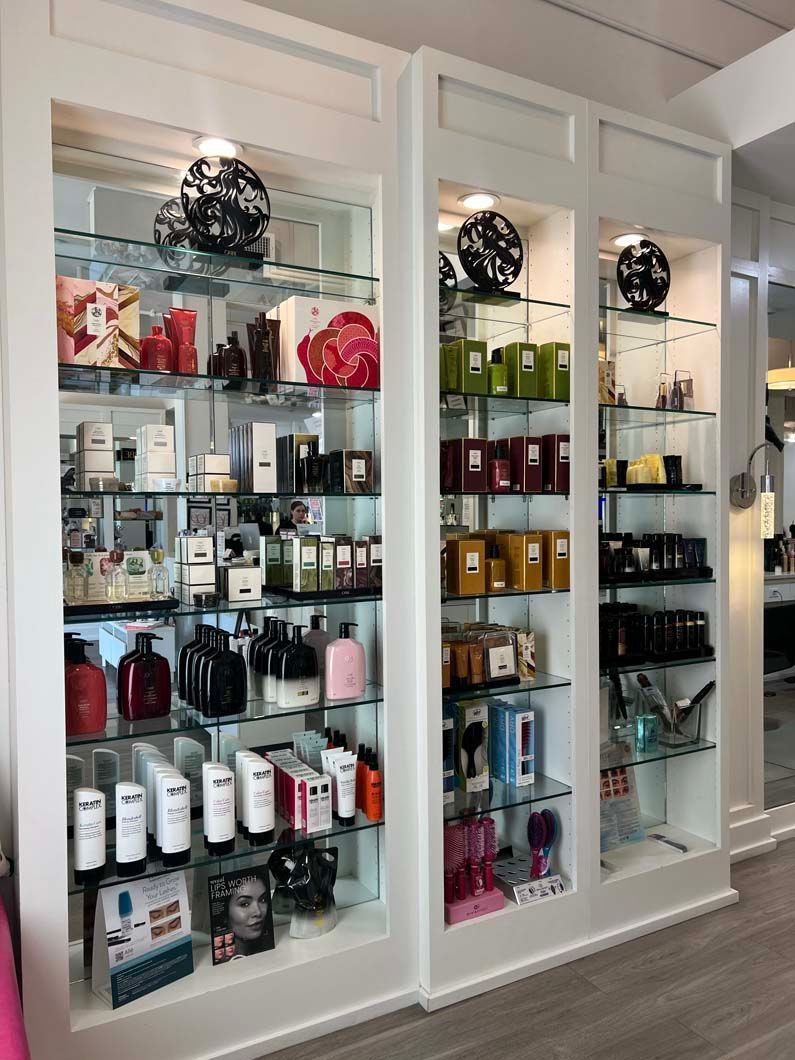 White display cases filled with beauty products, lit by overhead lights, in a brightly lit store.