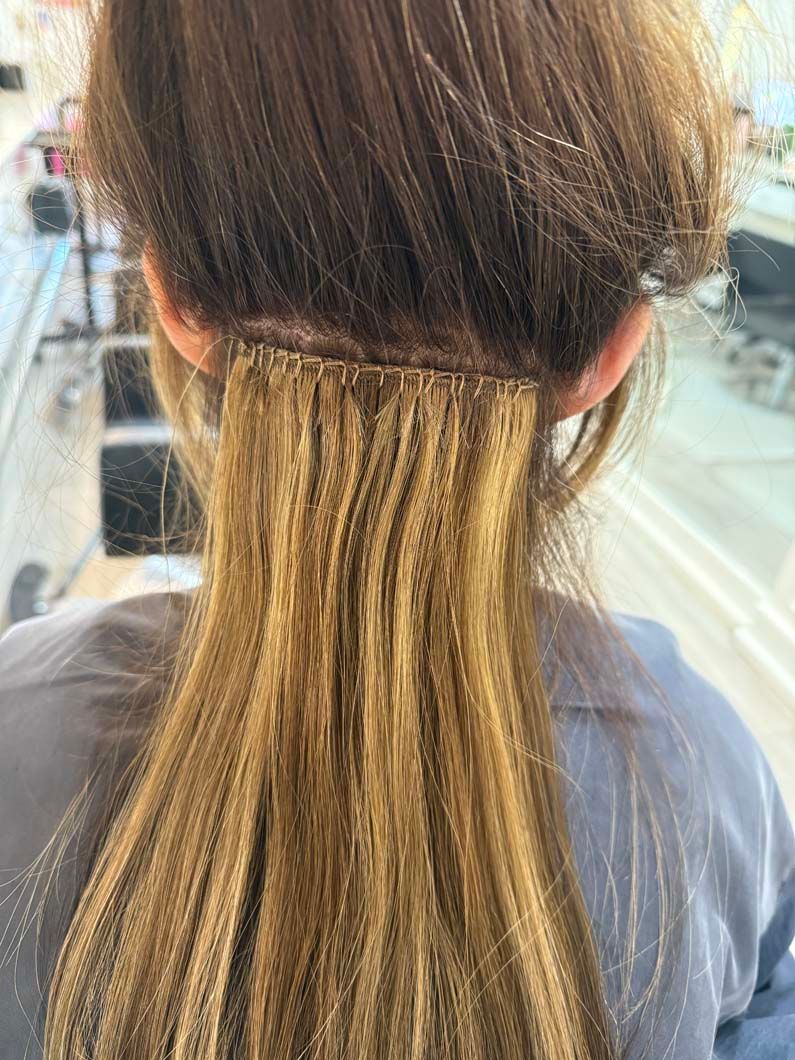 Woman's hair with crimped hair extensions attached near the scalp, light brown color.