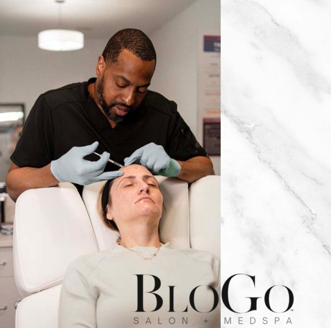 Person receiving injection in forehead at a salon, administered by someone wearing gloves.