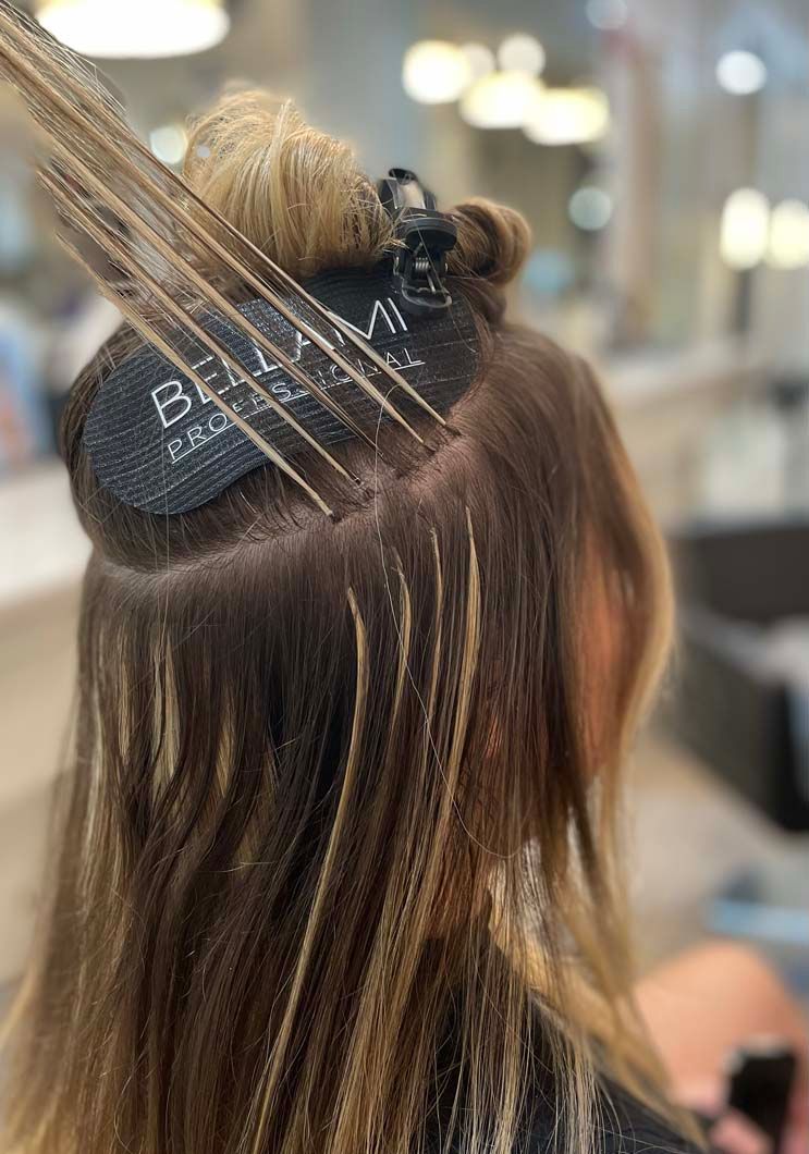 Hair being highlighted with foils in a salon, creating blonde streaks.