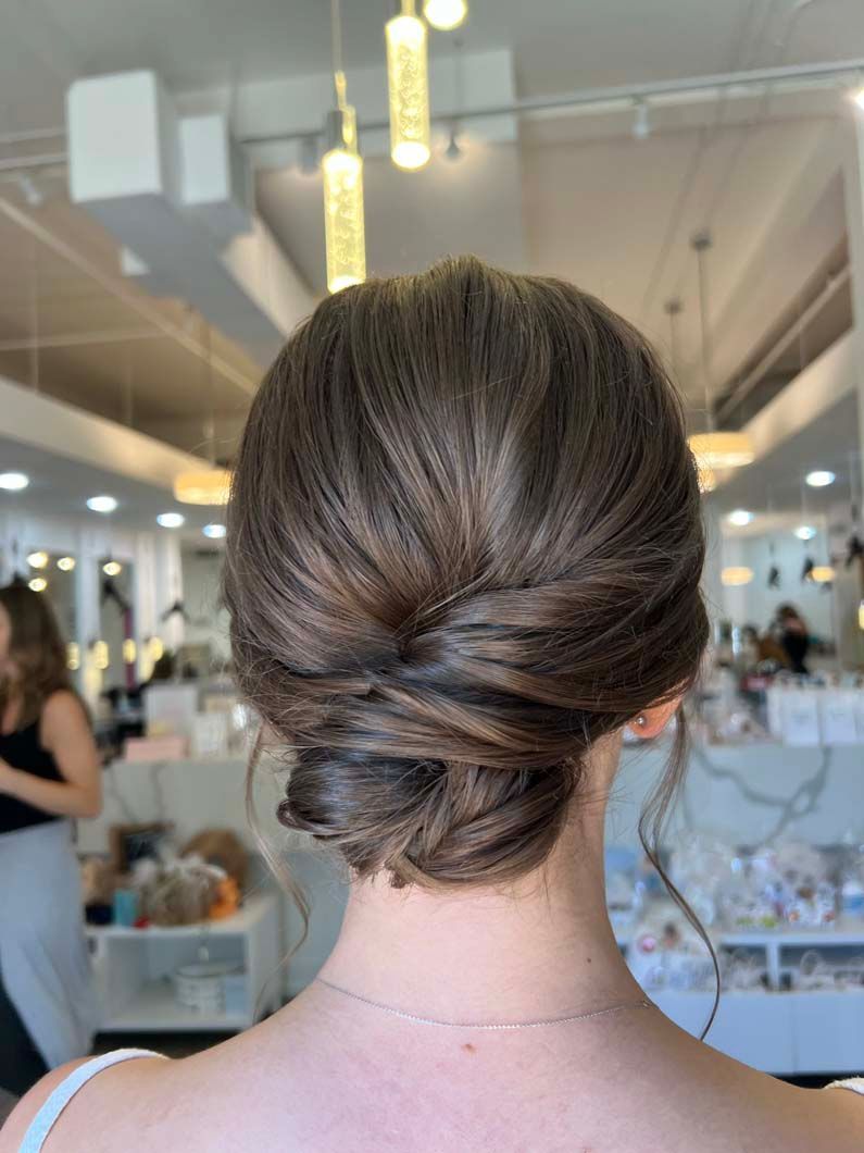 Elegant updo hairstyle with twisted bun, indoors.