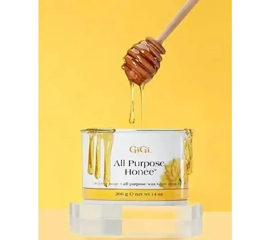Honey dripping from a wooden dipper into a GiGi All Purpose Honey tin on a yellow background.