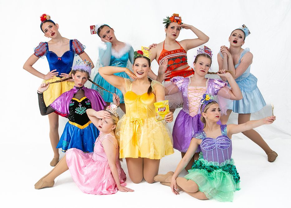 A group of young women dressed in princess costumes are posing for a picture.