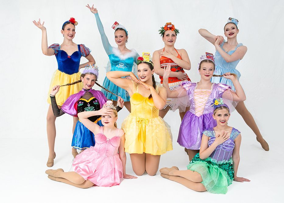 A group of young girls dressed in princess costumes are posing for a picture.