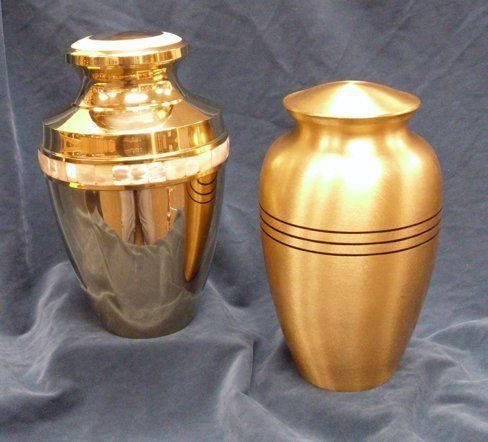 Two gold vases are sitting next to each other on a blue cloth
