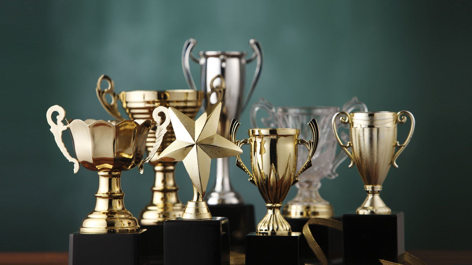 A group of trophies sitting on top of each other on a table.