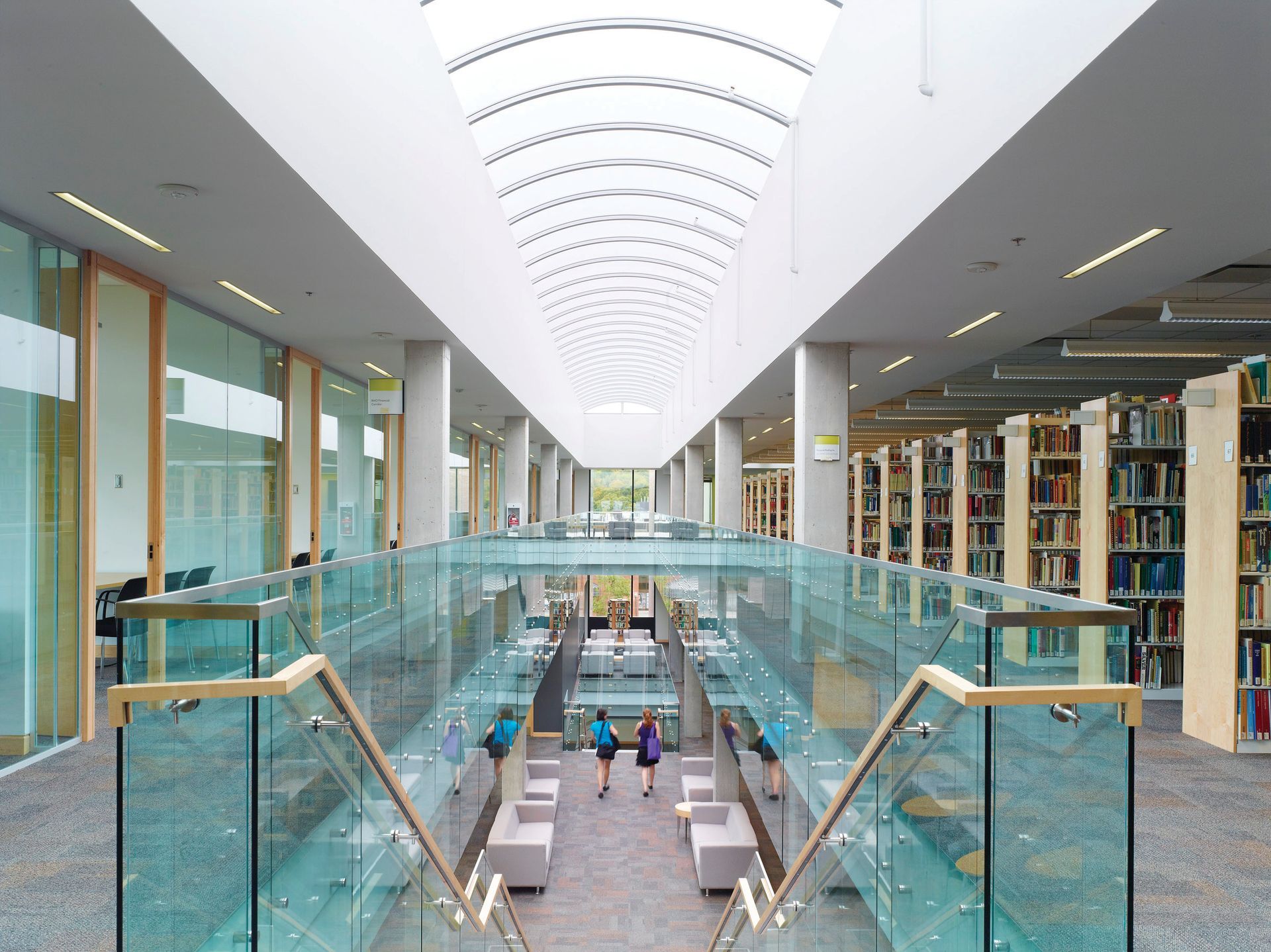 A group of people are walking down stairs in a library