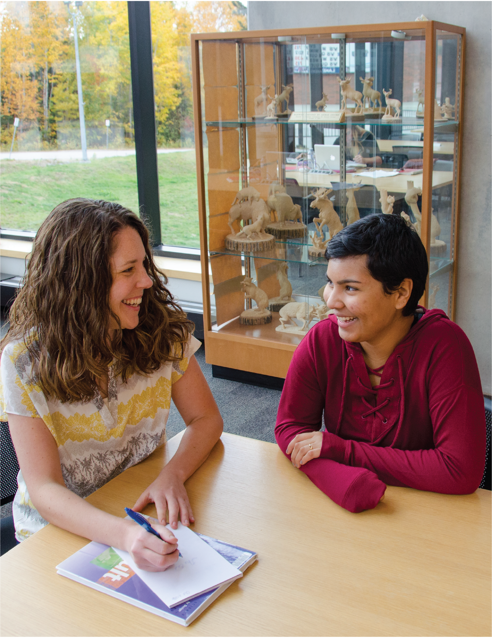 2 students talking in the library