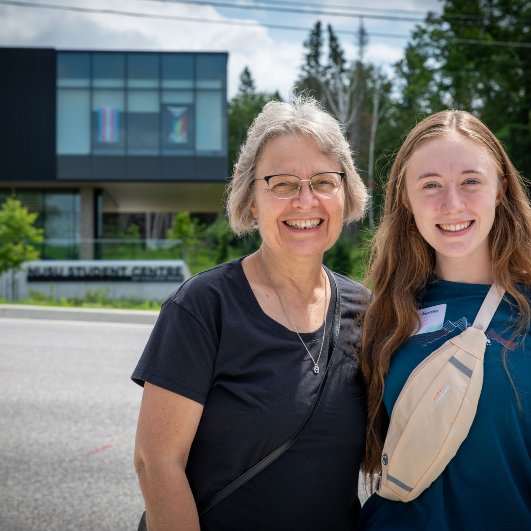 A grandmother and granddaughter posing in front of the student center