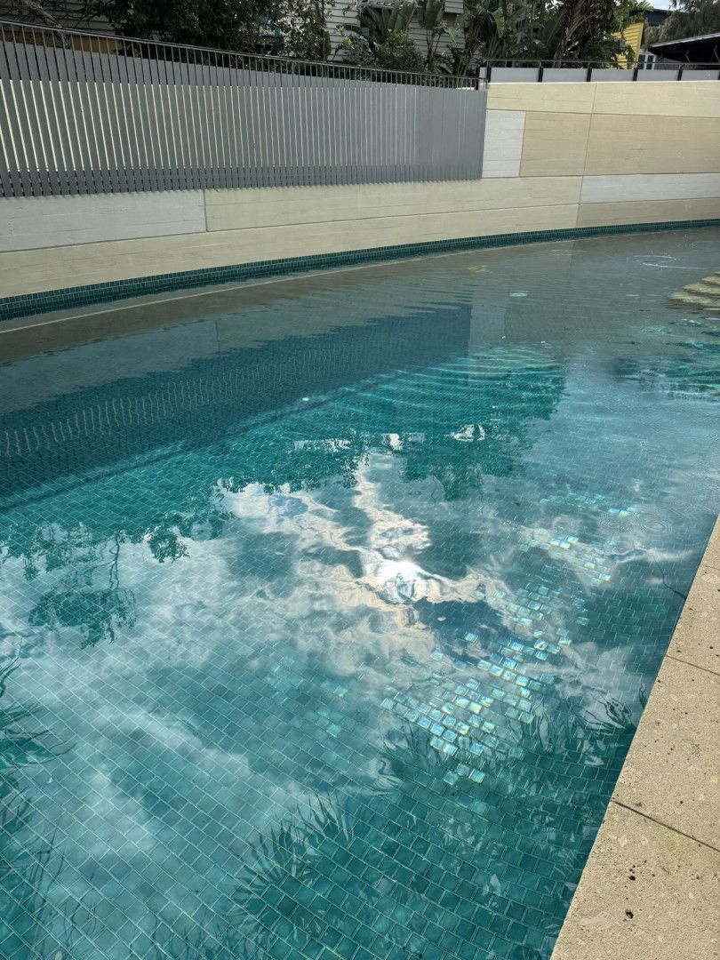 A Large Swimming Pool with A Fence in The Background — Poolside Noosa in Noosaville, QLD