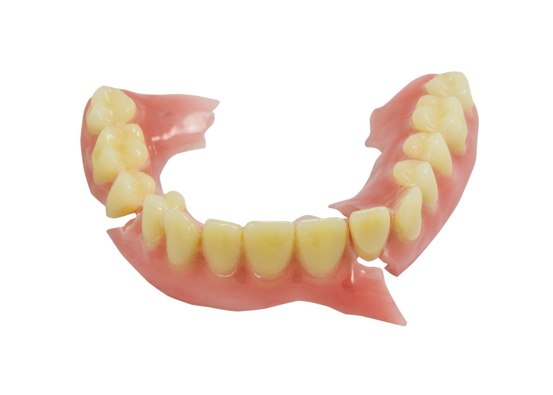 Broken upper denture, pink with yellow teeth.