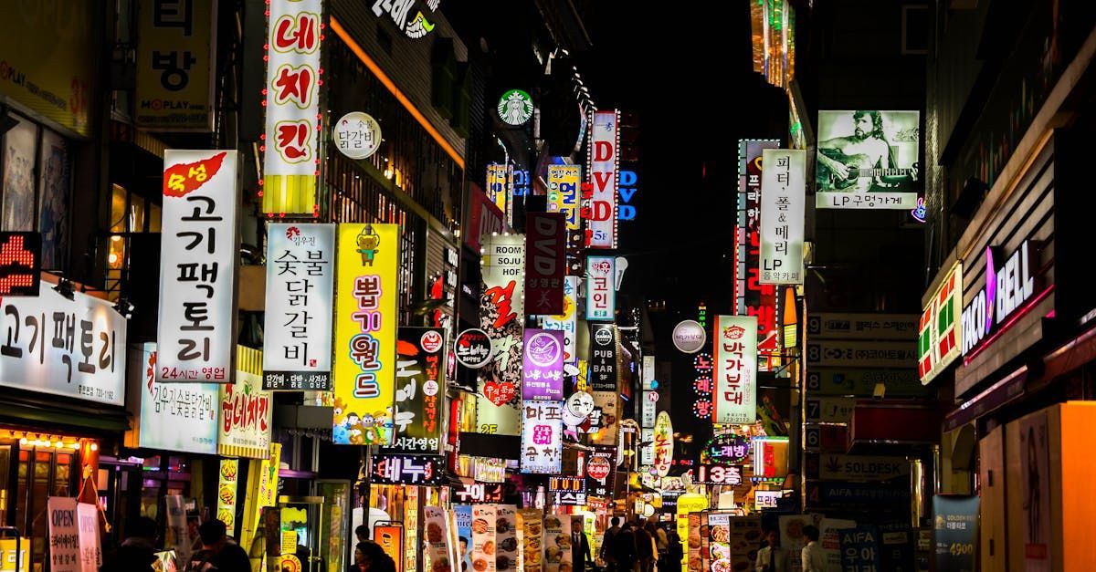 A busy city street at night with lots of signs and people walking down it.