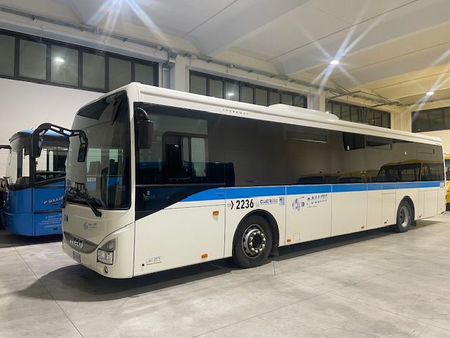 Autobus bianco con striscia blu, parcheggiato all'interno.