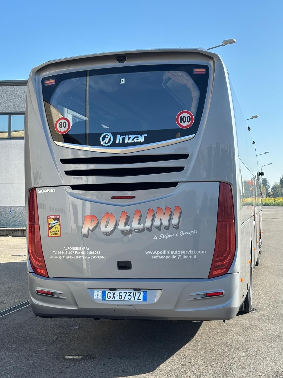 Vista posteriore di un autobus argentato con la scritta 