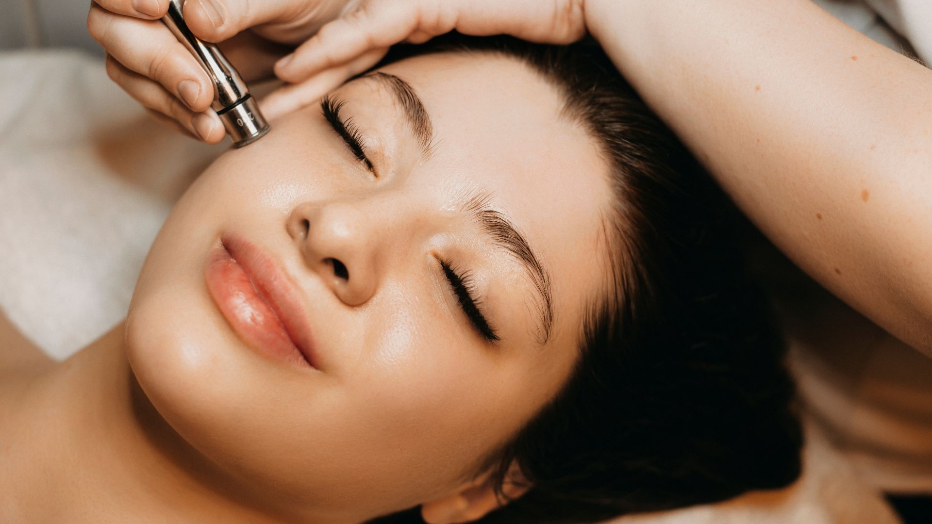 A woman is getting a facial treatment at a beauty salon.