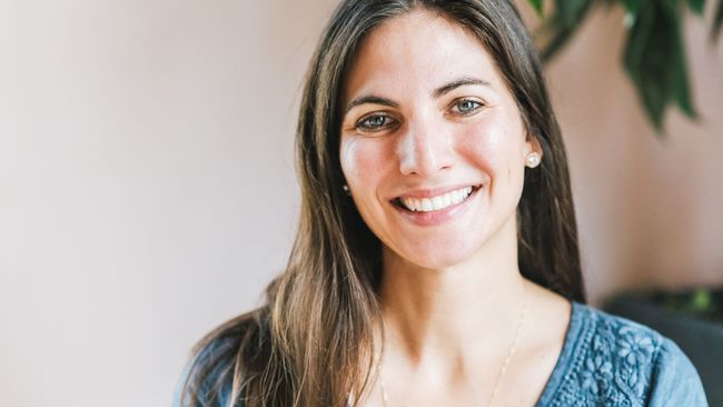 A woman with long hair is smiling for the camera.