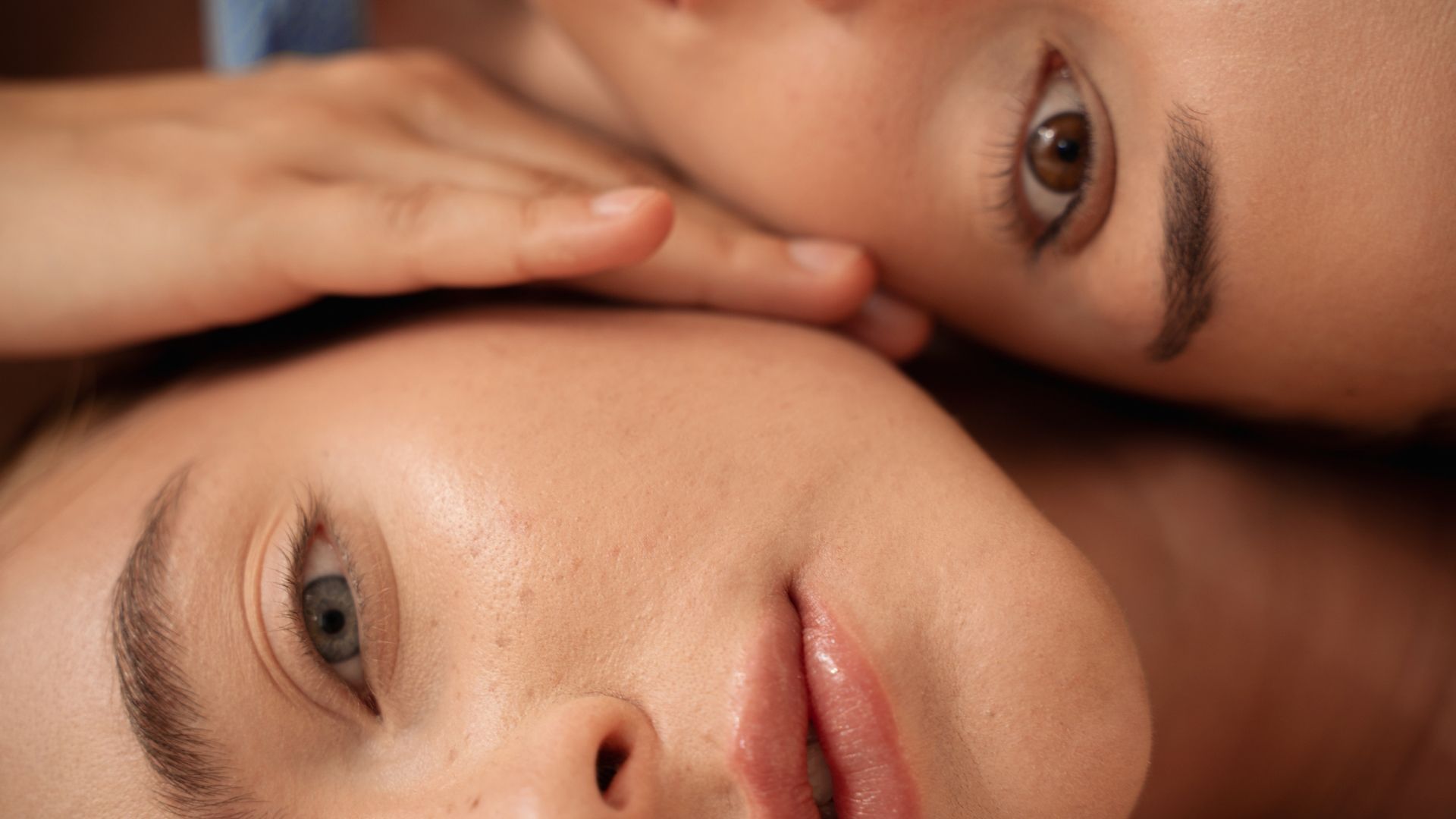 A close up of two women laying next to each other.