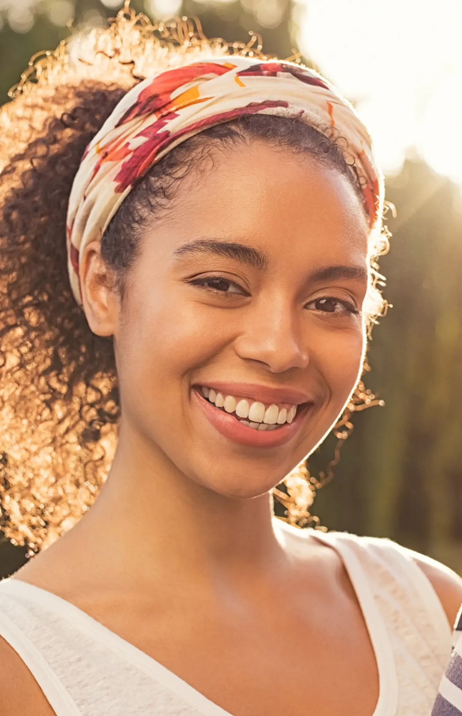 A close up of a woman wearing a headband and smiling.