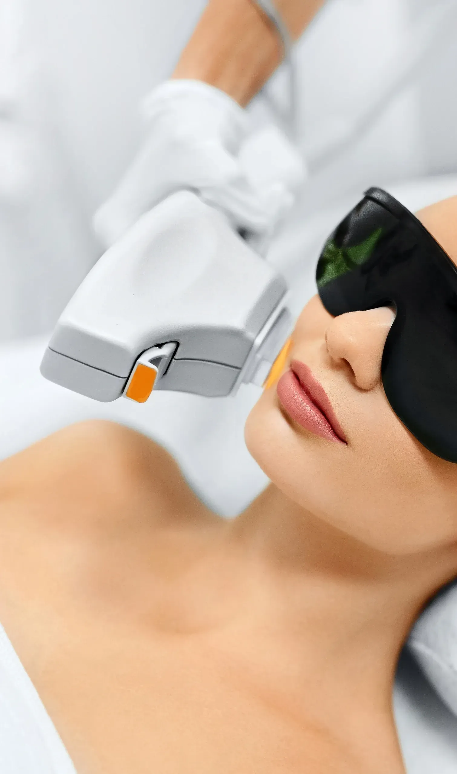 A woman is getting a laser hair removal treatment on her face.