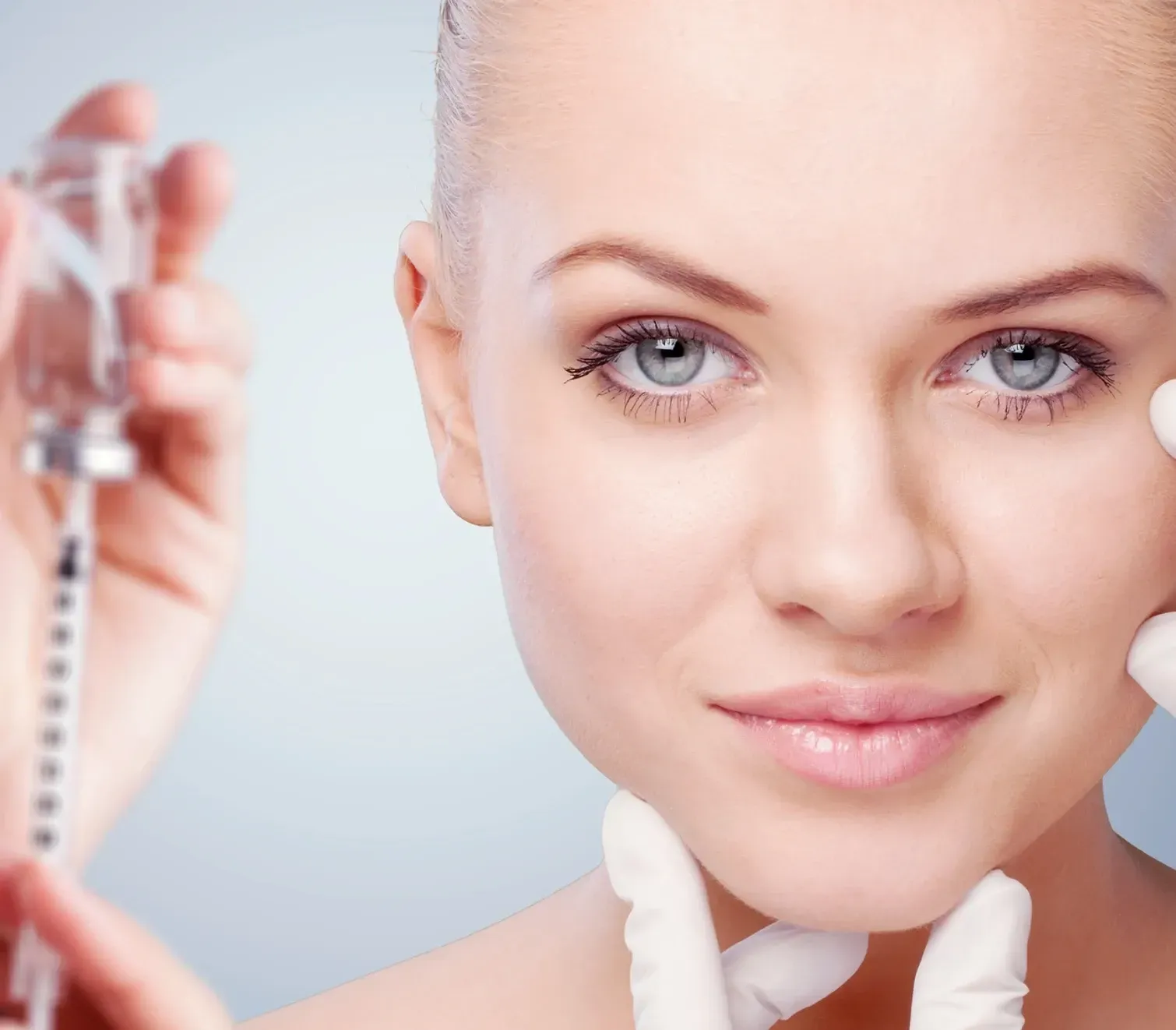 A woman is holding a syringe in front of her face
