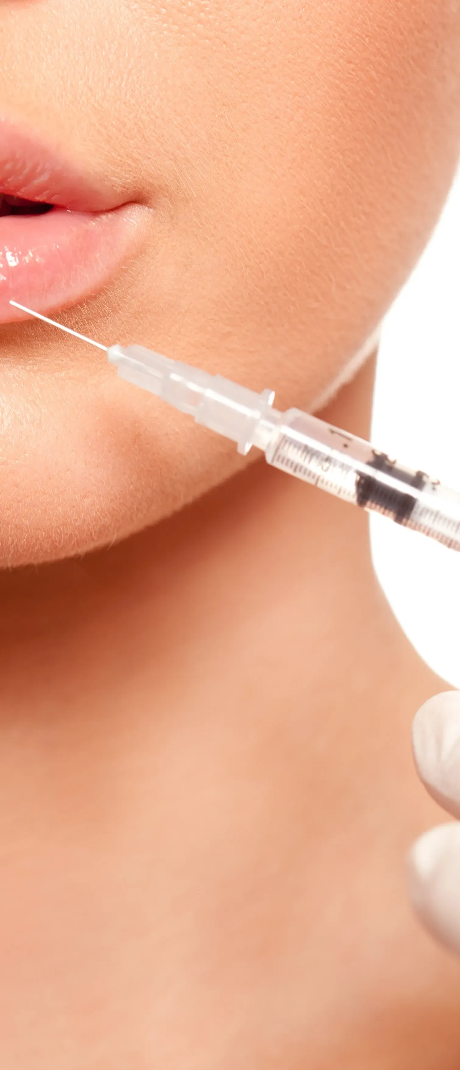 A woman is getting a botox injection in her lips.