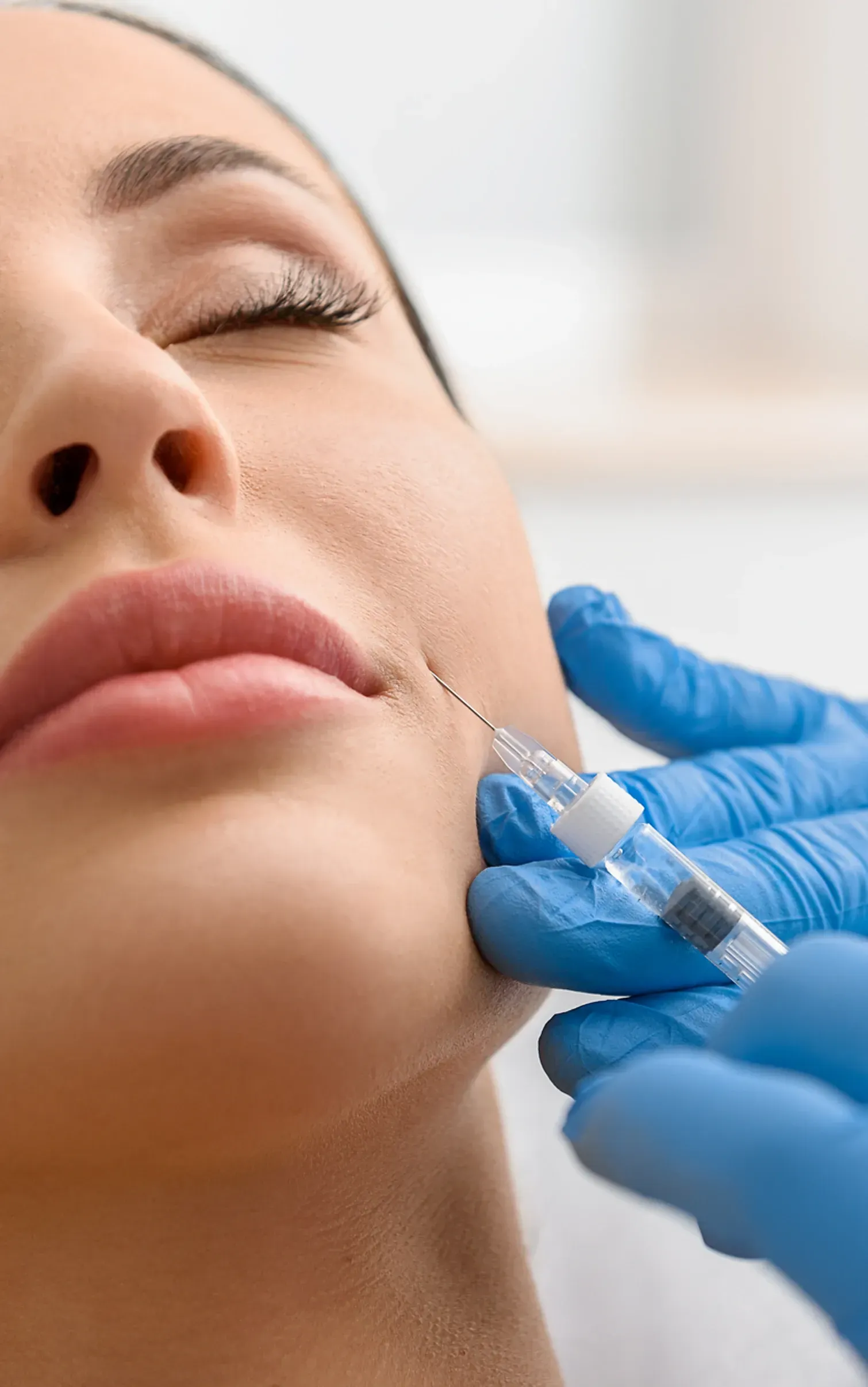 A woman is getting a botox injection in her face.