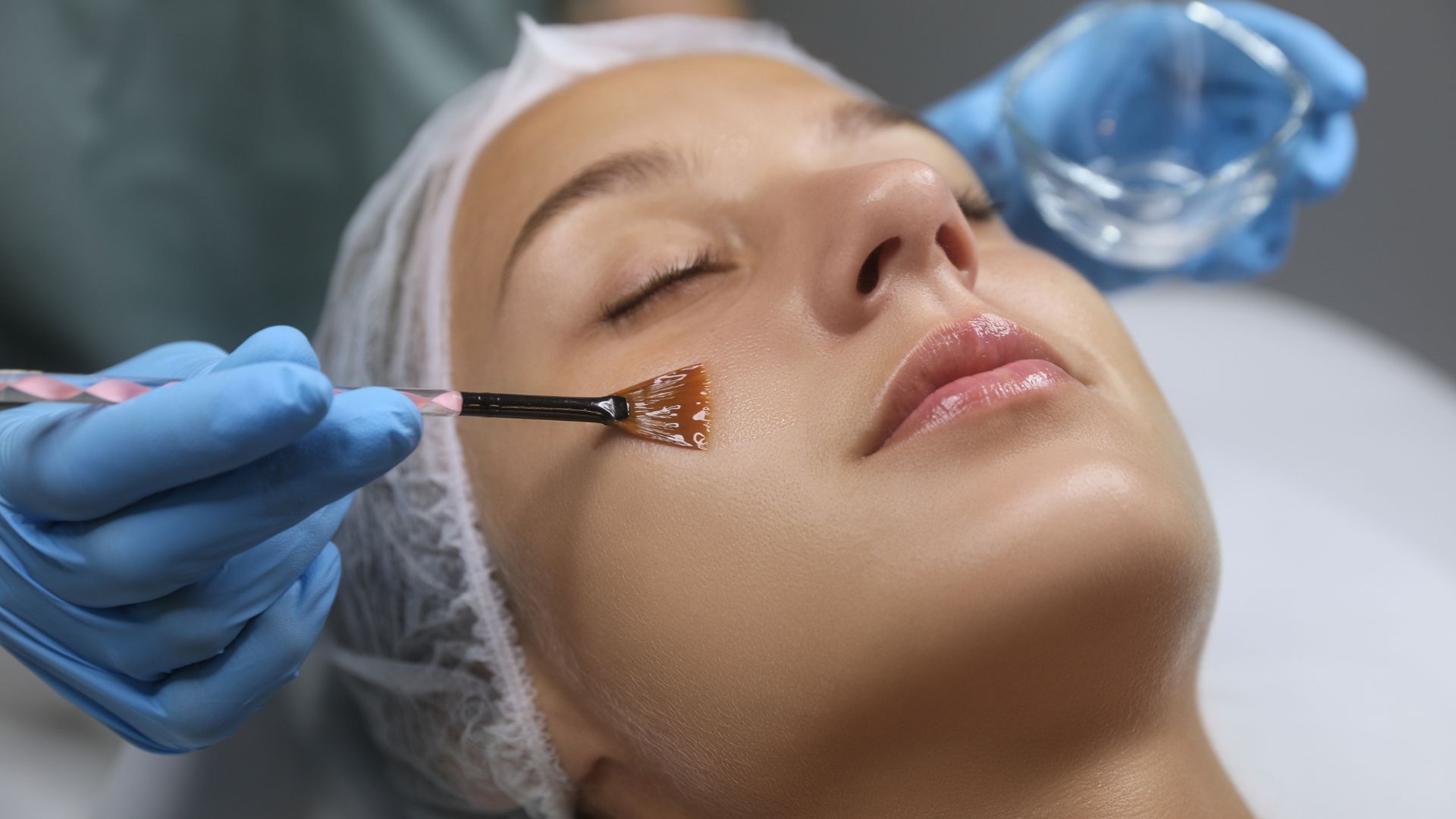 A woman is getting a facial treatment at a beauty salon.