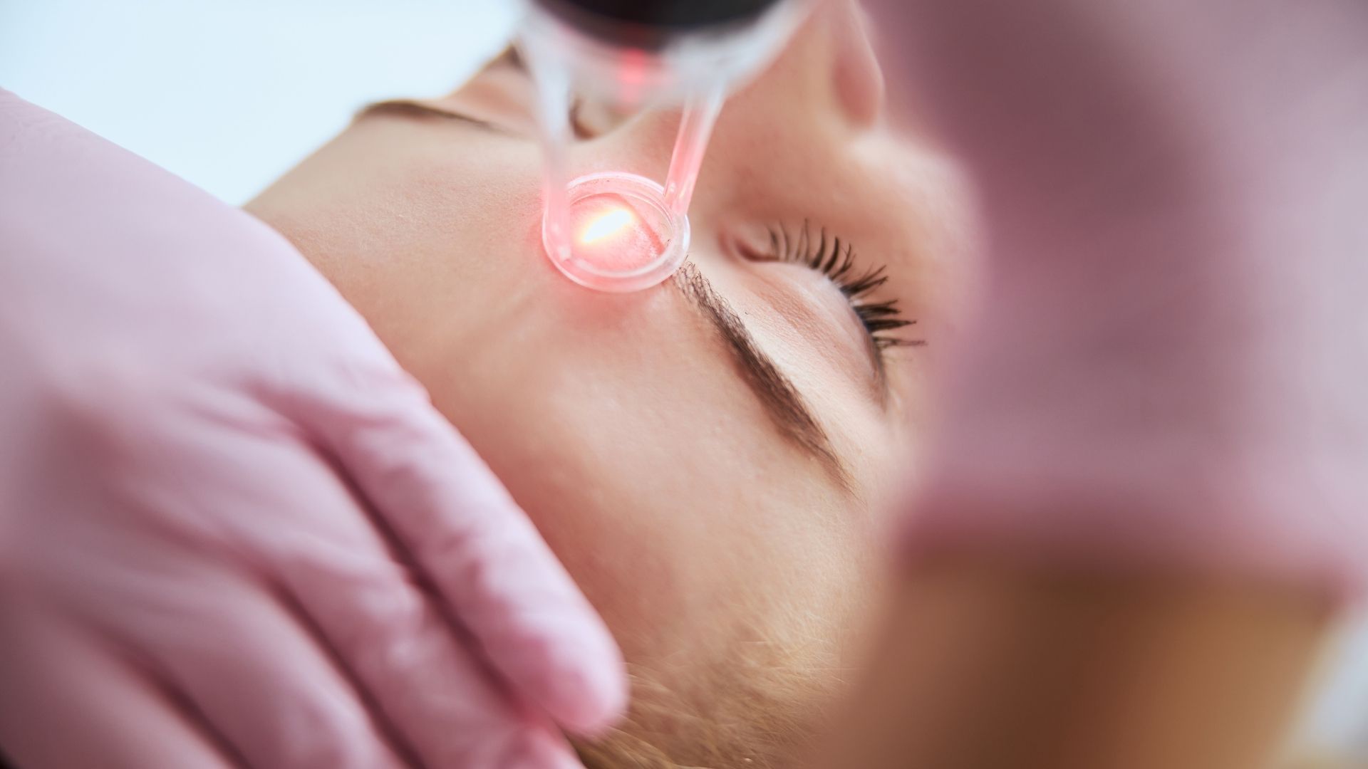 A woman is getting a laser treatment on her face.