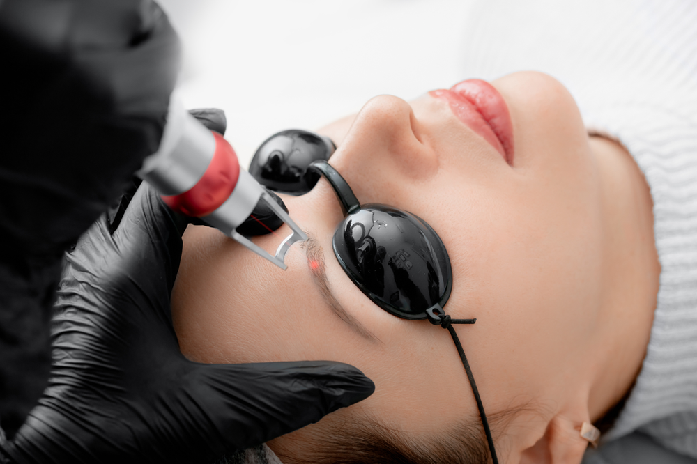 A woman is getting a laser treatment on her face.