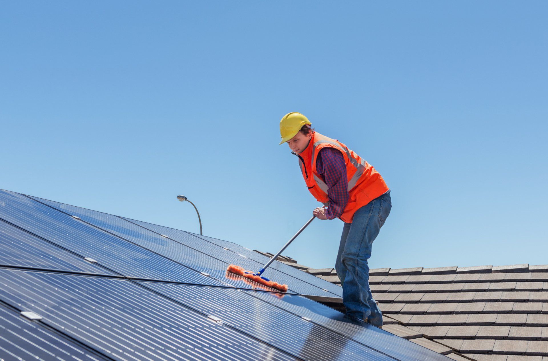 A Man On Roof Cleaning The Solar Panel — Myakka City, FL — Southwest Florida Pressure Washing