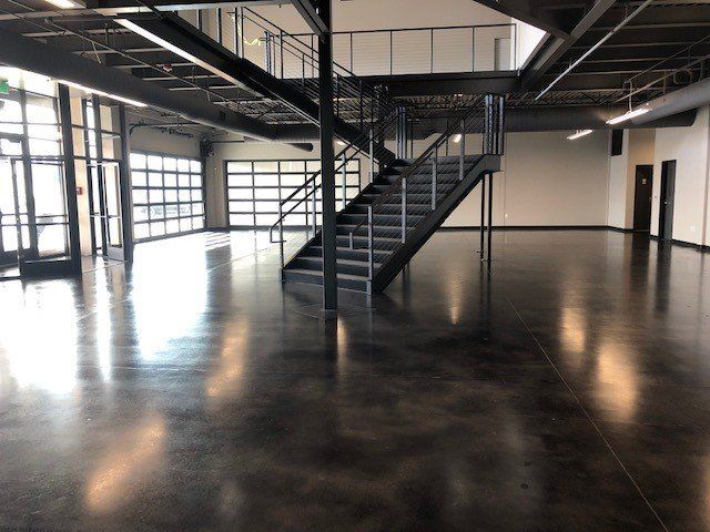 A large empty room with stairs leading up to the second floor