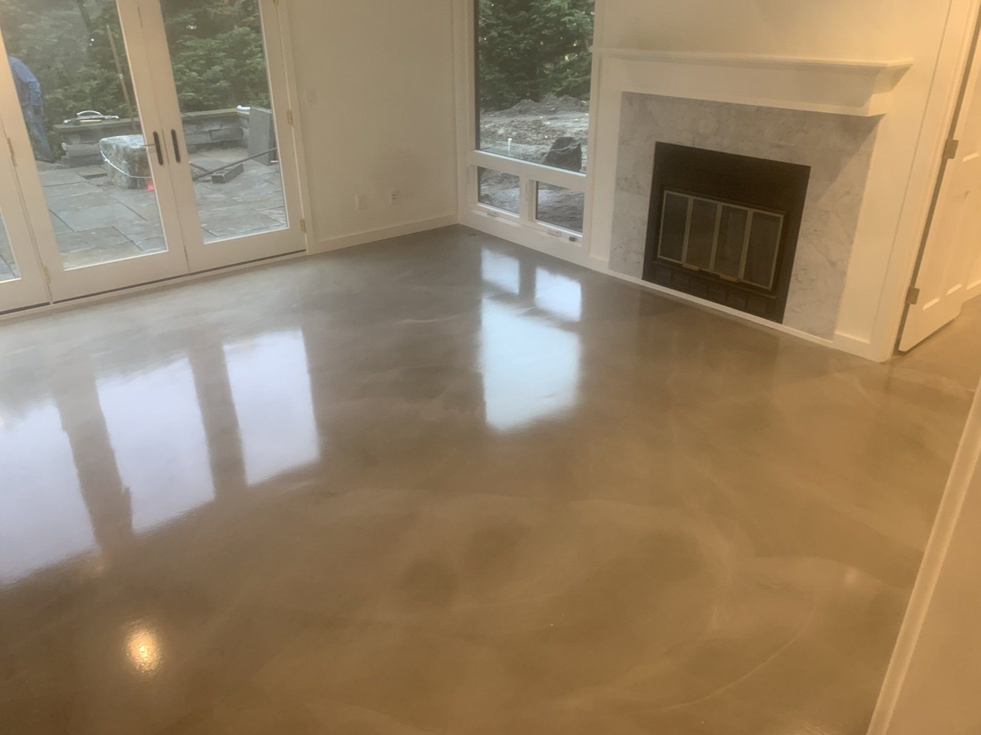 A living room with a fireplace and a concrete floor.